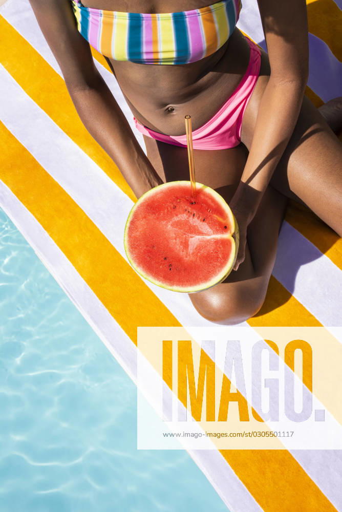 Young woman sitting with watermelon on sunny day model released, Symbolfoto, VRAF00183