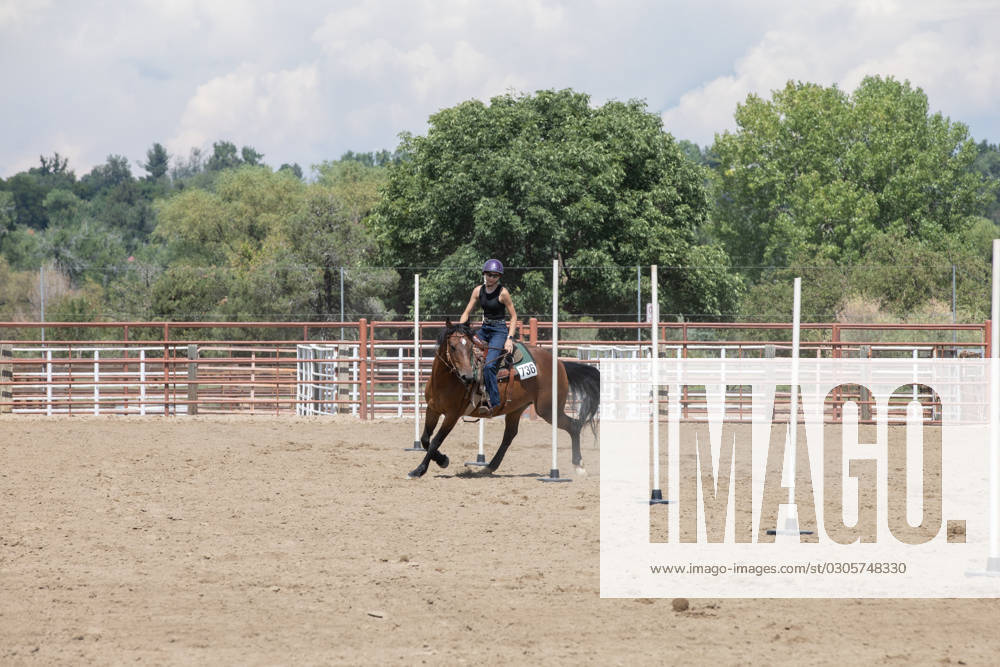 IMAGO Creative, Jahreszeit Sommer, Sommerferien Teenager girl running her horse around poles in arena Longmont, Colorado, United States R_SABO230907-1244623-01 ,model released, Symbolfoto