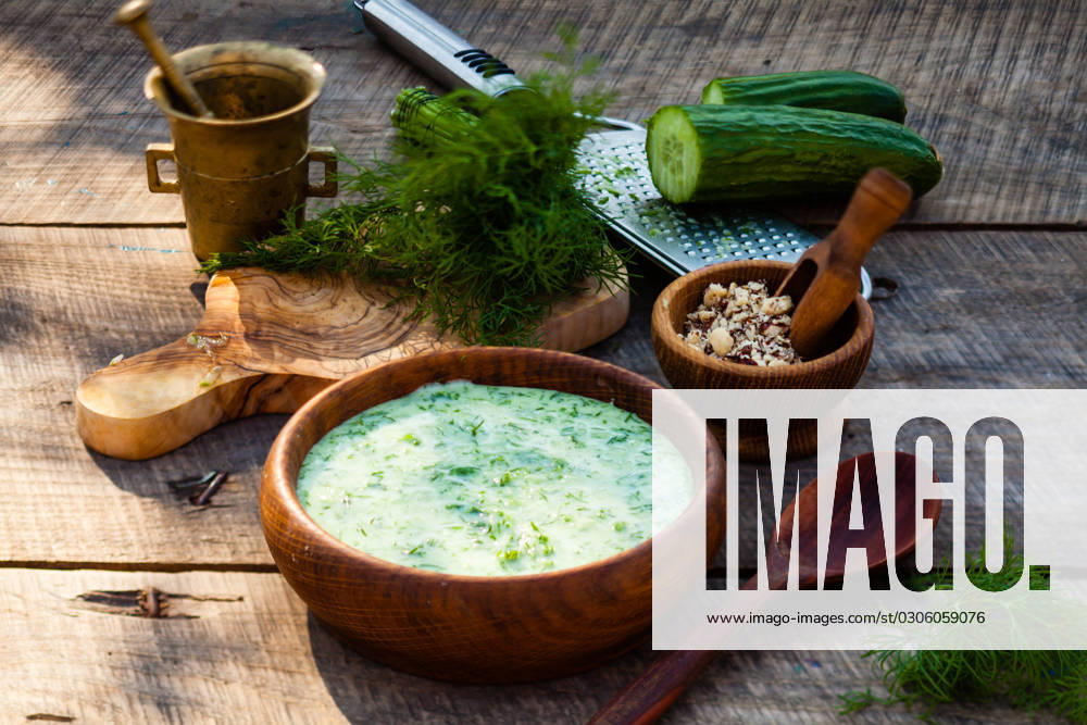 Homemade tarator with ingredients on wooden rustic background Homemade chilled tarator with ingredients on wooden rustic background. Traditional bulgarian summer cold soup with cucumbers, dill, garlic, yogurt and walnuts. ,model released, Symbolfoto