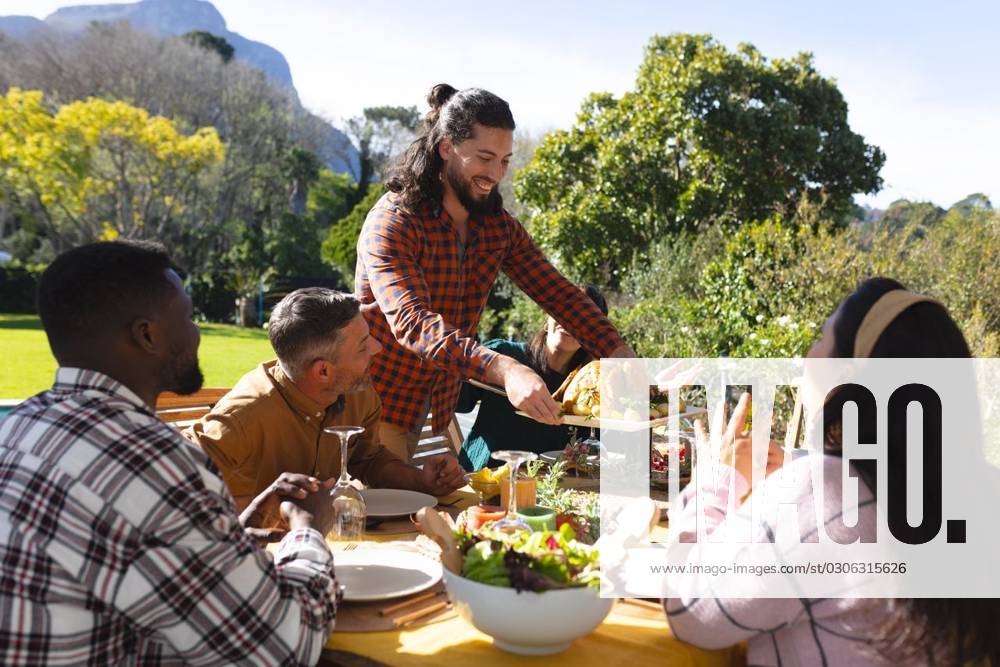 Happy diverse male and female friends serving thanksgiving celebration meal in sunny garden Happy diverse male and female friends serving thanksgiving celebration meal in sunny garden. Celebration, friendship, patriotism, american culture and tradition, unaltered., model released, , property released, Cape Town, South Africa, 07.09.2023, 4193326.jpg, people,happy,diverse,male and female,friend,serving,thanksgiving,celebration,meal,sunny,garden,friendship,patriotism,american culture,tradition,unaltered,holiday,patriotic,dinner,fun,nation,young,lunch,happiness,together,beautiful,spring,summer,party,food,traditional,season,christmas,cheerful,decoration,flag,male,female,american,culture Mature Adult,Man,Male,White,Mid Adult,Woman,Female,Multir
