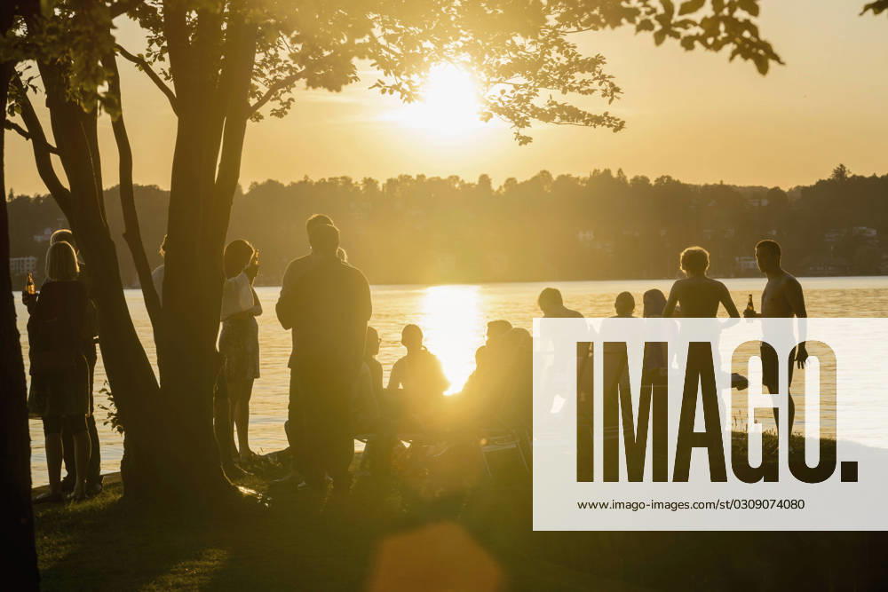 Group of young friends partying at lakeside during sunset, Bavaria, Germany Bavaria, Germany, Europe CR_RONI150802-00212-01 ,model released, Symbolfoto