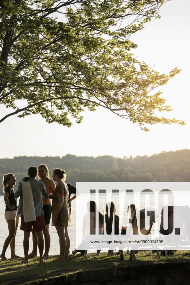 Group of young friends partying at lakeside during sunset, Bavaria, Germany Bavaria, Germany, Europe CR_RONI150802-00216-01 ,model released, Symbolfoto