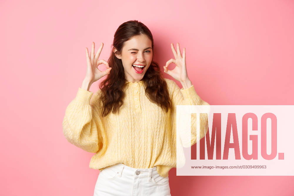 Portrait of cheerful pretty girl winking and saying yes, showing okay sign, alright gesture, praise good job, well done, standing pleased against pink background., model released, , property released, , 40402670.jpg, student, girl, spring, background, okay, good, approve, alright, agree, yes, praise, woman, advertising, fashion, beauty, person, portrait, female, grinning, joy, pink, beautiful, joyful, pleased, positive, smile, stylish, studio, horizontal, young, gesturing, glamour, holiday, excited, shopping, isolated, adult, girlfriend, advertisement, casual, smiling, emotive, slim, upbeat, glamorous, cheerful, emotions, excitement, fashionable, brunette RECORD DATE NOT STATED