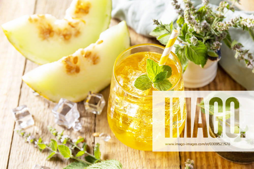 Fresh refreshing fruity summer drink, seasonal beverages. Melon lemonade in glasses with ice and mint on a wooden rustic table. Fresh refreshing fruity summer drink, seasonal beverages. Melon lemonade in glasses with ice and mint on a wooden rustic table.