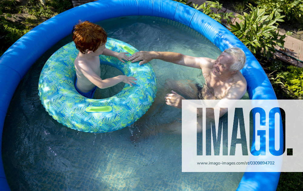 Grandfather and grandson spending leisure time in wading pool at garden model released, Symbolfoto, MBLF00001