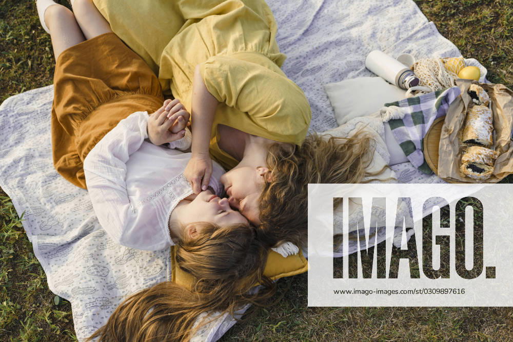 Mother and daughter rubbing noses and lying on picnic blanket model released, Symbolfoto, VBUF00400