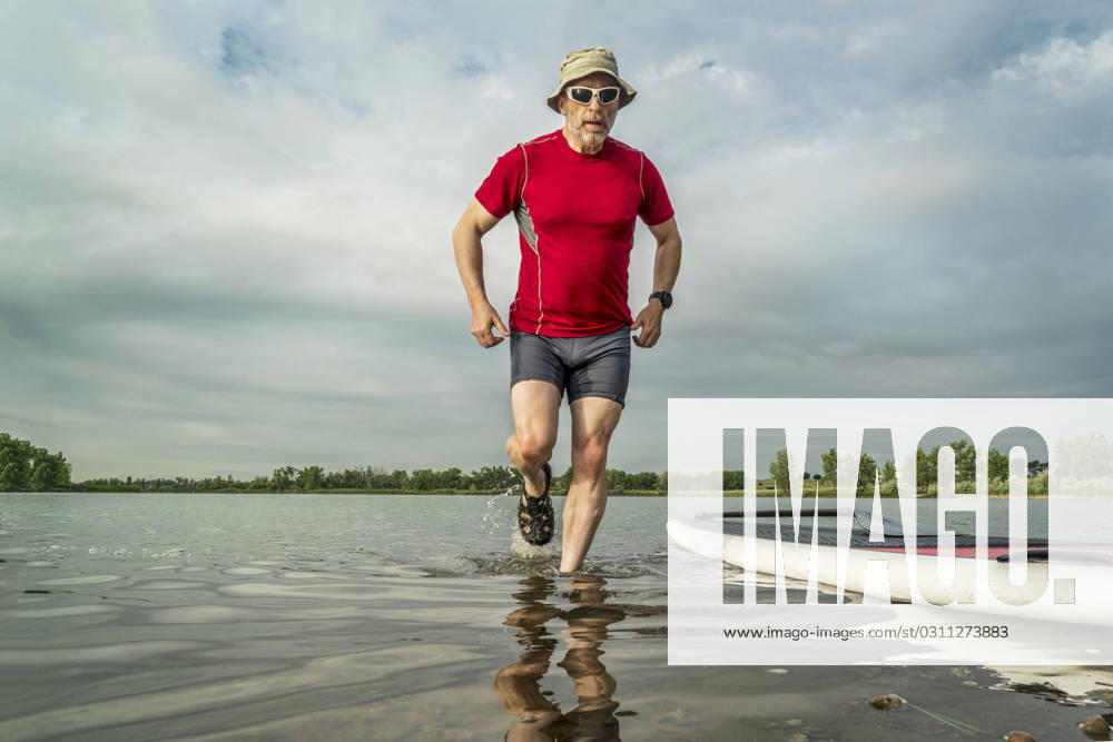 Senior paddler with stand up paddleboard senior paddler with stand up paddleboard on, lake shore in northern Colorado with an early summer scenery ,model released, Symbolfoto