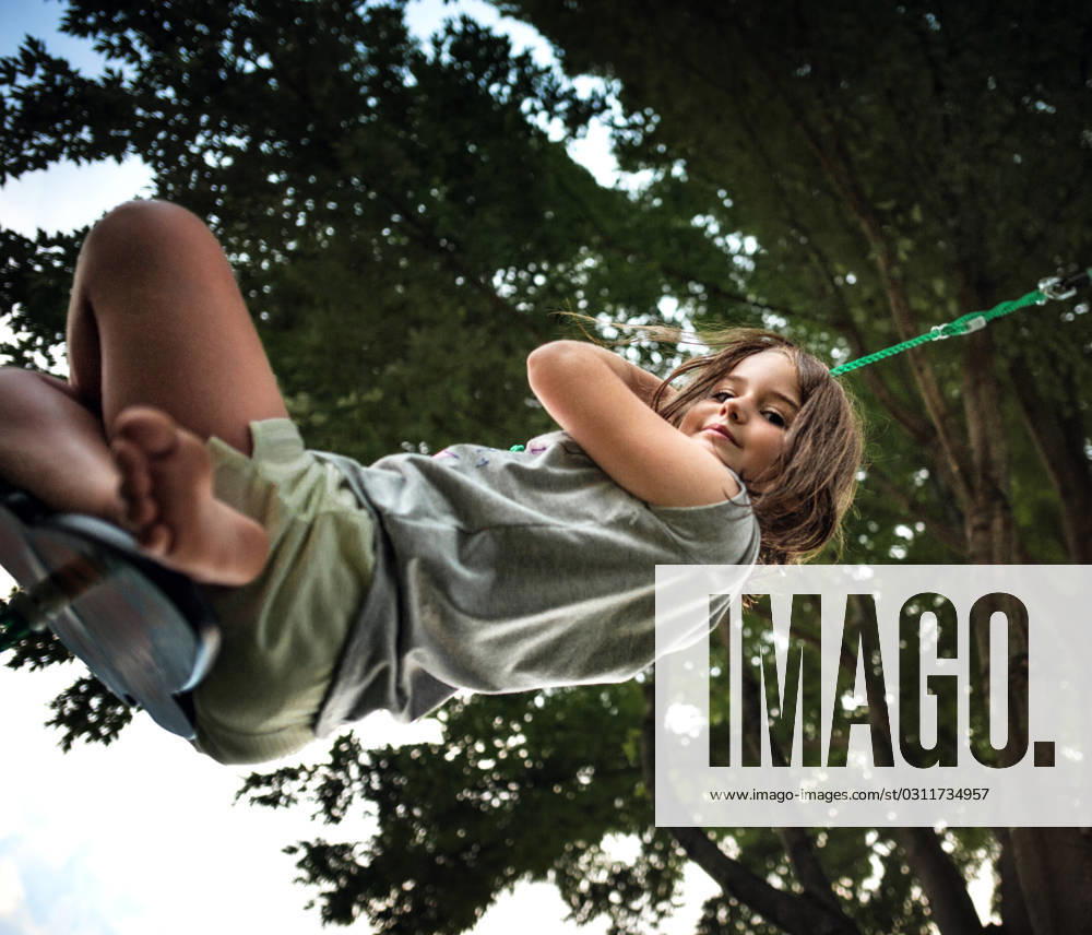 IMAGO Creative, Jahreszeit Sommer, Sommerferien Young happy girl playing on tree swing in summer Wooster, Ohio, United States CR_JOKU231030-1279823-01 ,model released, Symbolfoto