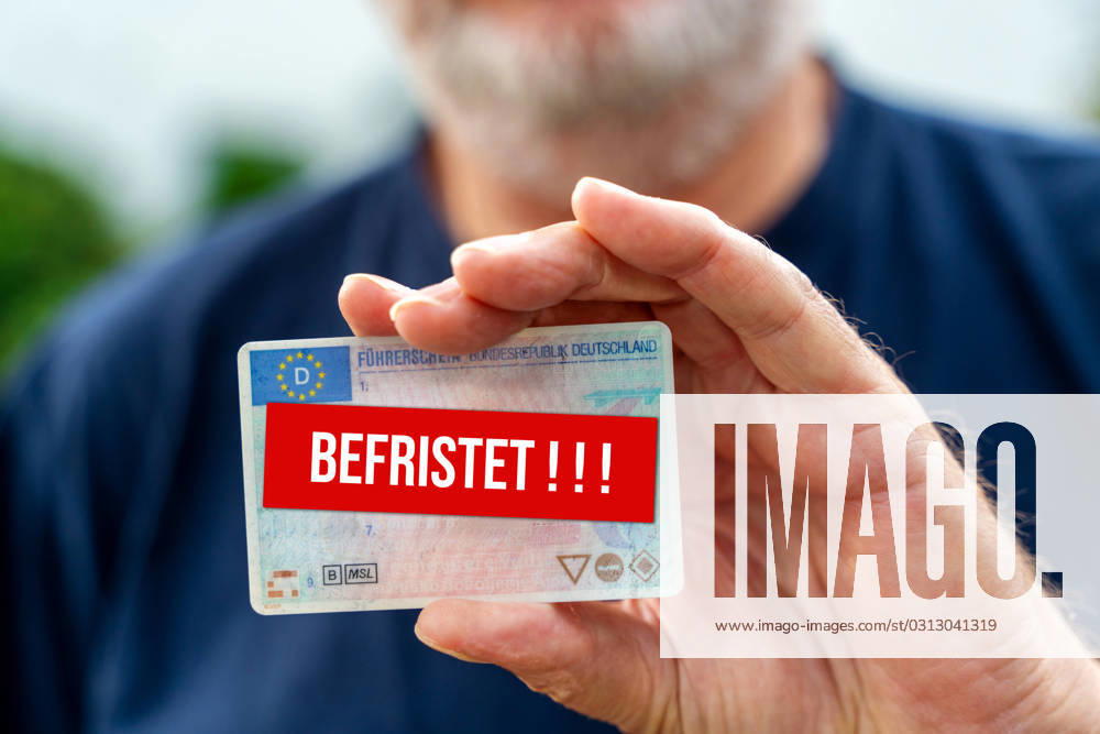 An old man with a beard holds a driver s license with the inscription Befristet. Driving safety and driver s license reform concept FOTOMONATE