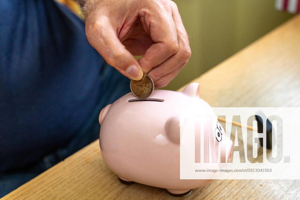 An old man throws euro coins into a piggy bank. Retirement provision concept