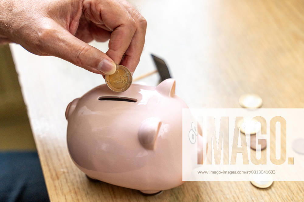 An old man throws euro coins into a piggy bank. Retirement provision concept