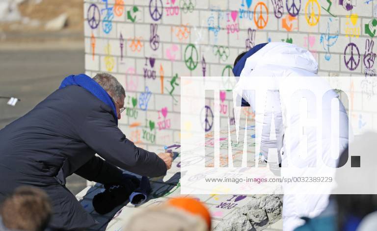 Pyeongchang Olympics International Olympic Committee President Thomas Bach (L) writes his signature on the Olympic Truce Wall at the athletes village in Pyeongchang, South Korea, on Feb. 5, 2018.