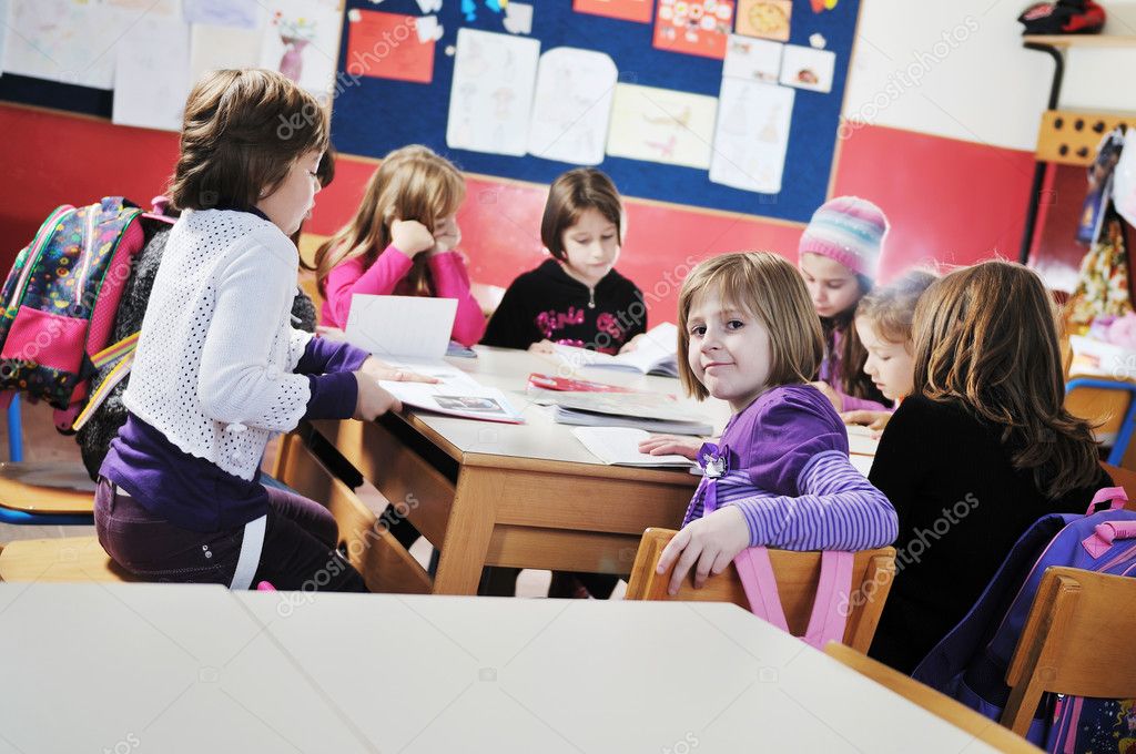 Happy young teacher woman at elementrary school teaching and giving leassons to group of young smart children model released