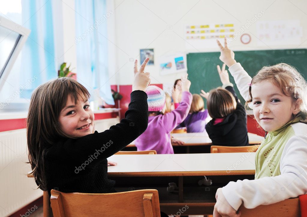 Happy young teacher woman at elementrary school teaching and giving leassons to group of young smart children model released