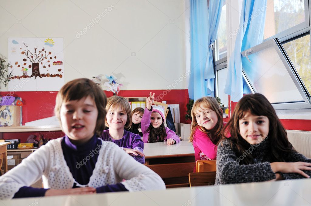 Happy young teacher woman at elementrary school teaching and giving leassons to group of young smart children model released