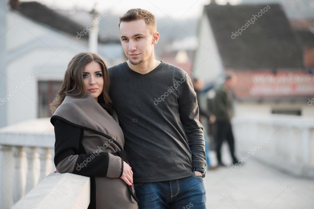 Attractive young couple standing on the bridge model released