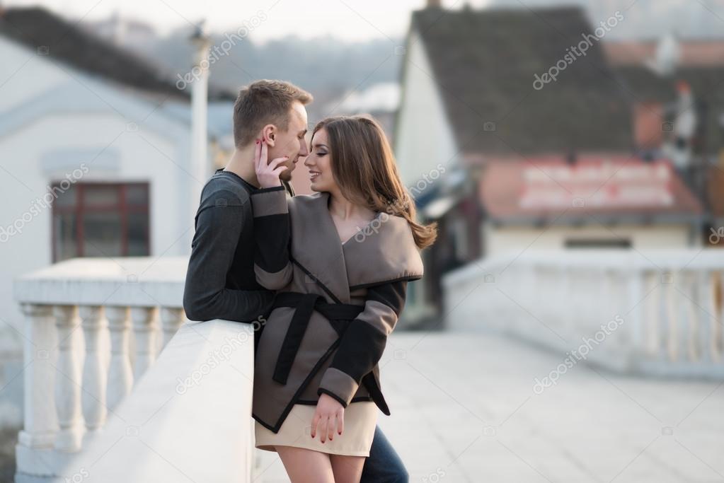 Attractive young couple standing on the bridge model released