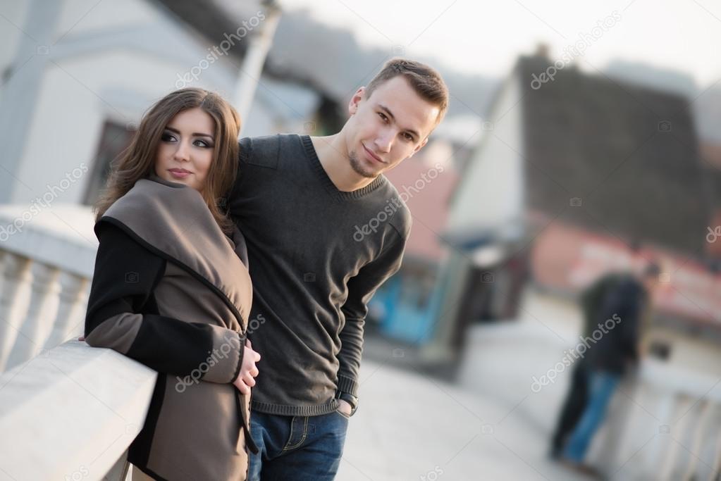 Attractive young couple standing on the bridge model released
