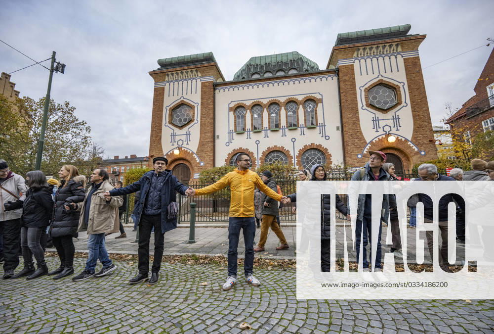 MALMÖ, SWEDEN 20231111 People hand in hand with the initiator Showan Shattak yellow jacket form a circle around the Synagogue in Malmö during a demonstration in support of Malmös Jews on Saturday The demonstration was a response to last weekends burning of the Israeli flag next to the Synagogue in Malmö and a new application for a similar d
