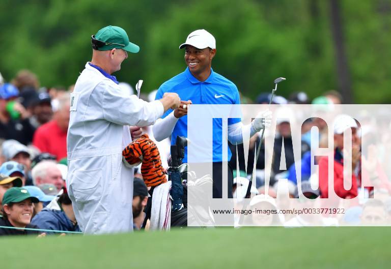 Tiger Woods fist bumps his caddie Joe LaCava after hitting on the 11th tee during the third round of the 2018 Masters Tournament at the Augusta National Golf Club in Augusta, Georgia, on April 7, 2018. AUG20180407308 KEVINxDIETSCH