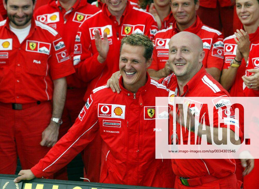 BRU462 - - FRANCORCHAMPS, BELGIUM : German Michael Schumacher and the whole Ferrari team pose for a family picture after the Belgian Formula One Grand Prix, Sunday 29 August 2004, on the race track of Spa-Francorchamps. Finnish Kimi Raikkonen won the race and Michael Schumacher got World Champion for the 7th time. MICHELxKRAKOWSKI x2141867x