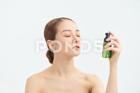 Beautiful Asian woman applying spray water on face on neutral background. naked, moisturizer, care, fresh, person, healthy, face, water, portrait, health, spa, spray, model, thermal, white, beautiful, freshness, bottle, skin, young, beauty, woman, liquid, clean, applying, wellness, treatment, background, closeup, girl, asian, vietnamese, korean, japanese, chinese