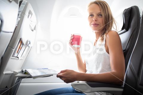 Young happy woman taking selfie photo with passport document sitting on the aircraft seat near a window during the flight in the airplane adult, air, aircraft, airline, airplane, business, cabin, clouds, comfortable, commercial, document, economy, female, flight, fly, girl, happy, holiday, indoor, interior, journey, passenger, passport, people, person, plane, portrait, seat, self, selfie, sitting, tourism, tourist, transport, transportation, travel, traveling, trip, vacation, window, woman, young