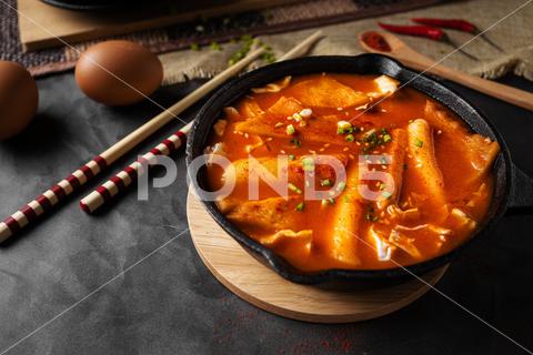 A horizontal shot of a soup in black bowl and some eggs and wooden chopsticks soup, dish, dinner, gourmet, healthy, plate, lunch, cooked, sauce, bowl, hot, meal, white, cooking, food, homemade, closeup, portion, sliced, fresh, seafood, cuisine, top, nobody, restaurant, background, parsley, fried, asian, appetizer, spoon, chinese, pot