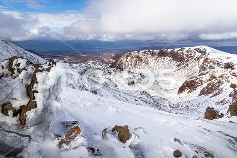 View from near the top of Mount Tongariro, in the Central Plateau of the North Island of New Zealand, in the middle of winter. adventure, alpine, alps, aotearoa, central plateau, climbing, cold, crossing, ice, snow, ecotourism, glacier, domestic, hike, holiday, tramping, landscape, mountain, mountaineering, national, natural, park, new zealand, nz, outdoor, peak, rock, scenery, view, seaon, ski, snowboard, tongariro, tourism, travel, trekking, volcano, white, winter, harsh, dramatic, destination, ruapehu, whakapapa