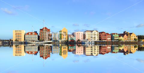 A beautiful shot of colorful building in the city with reflection on water beautiful, shot, colorful, color, building, city, reflect, reflection, blue, sky, background, landmark, facade, architecture, architectural, cityline, water, river, cloudscape, colored, splash, cityscape, downtown, urban, skyscraper, travel, business, structure, skyline, curacao, tourism