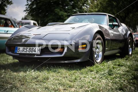 The sports car Chevrolet Corvette Stingray (C3). Focus on center. Swirly bokeh. The exhibition of "US Car Classics". america, american, ancient, antique, auto, automobile, automotive, car, classic, design, diedersdorf, exhibition, germany, machine, model, nostalgia, old, oldtimer, retro, style, transport, transportation, us, usa, vehicle, engine, sports car, Chevrolet, Corvette, coupe, 2-door, c3, Vette, muscle car, exterior, Stingray, Focus, center, Swirly, bokeh