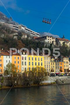 View on Grenoble with cable car in France outdoors. France, Grenoble, europe, travel, city, view, architecture, mountain, landscape, cable, sky, urban, building, car, landmark, town, cityscape, river, water, hill, cablecar, old, transport, houses, blue, cableway, french, panorama, transportation, way, outdoor, downtown, cabin, nobody, viewpoint, mount, horizontal, destination, elevator, high, european, skyline, historic, history, colorful, image, bridge, center