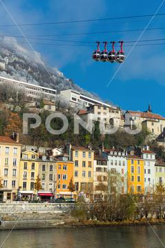 View on Grenoble with cable car in France outdoors. France, Grenoble, europe, travel, city, view, architecture, mountain, landscape, cable, sky, urban, building, car, landmark, town, cityscape, river, water, hill, cablecar, old, transport, houses, blue, cableway, french, panorama, transportation, way, outdoor, downtown, cabin, nobody, viewpoint, mount, horizontal, destination, elevator, high, european, skyline, historic, history, colorful, image, bridge, center
