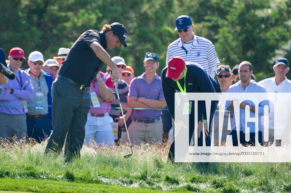 Phil Mickelson confers with a USGA official near the 12th green in the first round of the 118th U.S. Open Championship at Shinnecock Hills Golf Club in Southampton, New York on June 14, 2018. NYP20180614133 COREYxSIPKIN