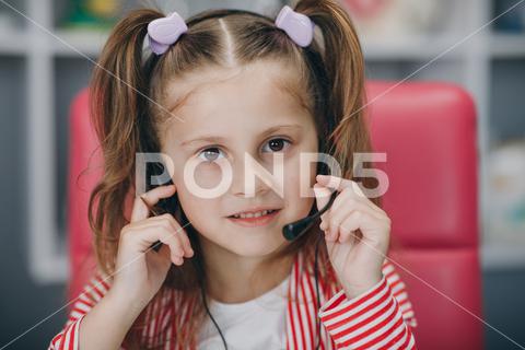 Portrait of smiling little girl wearing headphones. Happy small preschooler child in earphones have fun. Studying online on quarantine audio, listening, joy, smile, lifestyle, picture, little, make notes, write, notebook, play, online search, paint quarantine, people prepare, perfect look, portrait sitting, positive education, primary educate, pupil school, research study, screen technology, small success, smart watch, intelligent person, home leisure, headset laptop, headphones wireless, book knowledge, camera take, casual wear, caucasian female, cheerful happiness, child handwrite, childhood concept, class lesson, computer webcam, successful kid, desk paperwork, doing homework, earphones table, entertainment music, exam preparation, examination room, fun task