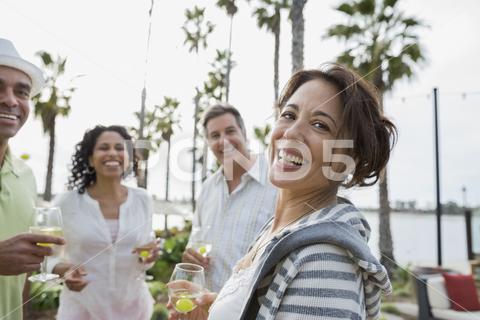 Portrait of smiling friends enjoying drinks on patio at resort, Resort Friends caucasian, ethnicity, looking, away, smiling, standing, head, and, shoulders, multi-ethnic, enjoyment, friendship, holding, four, people, togetherness, couple, outdoors, casual, clothing, bonding, happiness, beverage, african, american, wineglass, baby, boomer, 55-59, years, 40-44, 45-49, heterosexual, drink, refreshment, day, focus, on, foreground, leisure, activity, lifestyles, waist, up, weekend, activities, mature, adult, men, women, beautiful, food, vacations, alcohol, mixed, race, person, series, san, diego, california, united, states, hispanic, latin, tourist, resort, grape, palm, tree