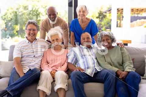 Portrait of happy multiracial male and female senior friends relaxing in living room at nursing home. Smiling, sofa, window, unaltered, togetherness, support, assisted living and retirement concept. Medium Group Of People, Mature Adult, Man, Male, Caucasian, Senior, Elderly, Black, Mixed-Race, Woman, Female, People, Portrait, Happy Multiracial, Male Female, Friend, Relaxing, Living Room, Nursing Home, Smiling, Sofa, Window, Unaltered, Togetherness, Support, Assisted, Retirement, Couch, Young, Cheerful, Happy, Apartment, Adult, Comfortable, Retired, Together, Happiness, Attractive, Furniture, Person, Indoors, Lounge, Room, Home, Armchair, Friendship, Sitting, Multiracial, Living, Nursing