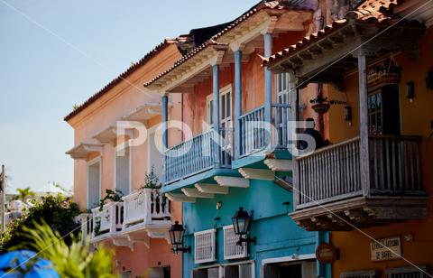 A beautiful shot of a colorful building in the historic part of Cartagena architecture, balcony, beautiful, building, cartagena, city, colorful, columbia, destination, exterior, facade, historic, historical, history, landmark, old, street, town, travel, urban, view, wall, window
