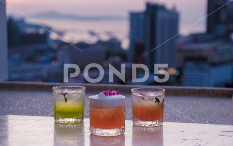 Cocktail drinks on a rooftop bar in Pattaya Thailand during sunset Pattaya, Thailand, bar, drink, cocktail, restaurant, alcohol, glass, party, rooftop, fun, table, celebration, dinner, happy, outdoor, city, fruit, mojito, beverage, food, lifestyle, people, refreshment, friends, holiday, pub, sky, background, cold, fresh, juice, skyline, toasting, cafe, cheerful, smile, woman, beautiful, luxury, cityscape, cool, ice, lemon, lime, mint, soda