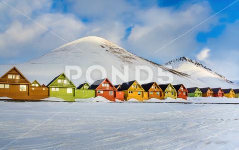 Colorful houses in the Longyearbyen settlement on the island of Spitsbergen, Svalbard, Norway Color, architecture, arctic, attraction, beautiful, cabin, cold, colorful, cottage, cruise, dwelling, europe, famous, freeze, frozen, house, houses, hut, lodge, miner, mountain, nordic, north, norway, norwegian, outdoor, peak, polar, pole, popular, postcard, poster, quaint, row, scandinavia, settlement, sight, sightseeing, snow, spitsbergen, svalbard, tourism, tourist, town, travel, village, wooden