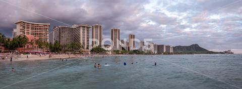 Honolulu, Hawaii - December 29, 2022: View of Waikiki Beach with Diamond Head valcano in the distance. architecture, beach, building exterior, city life, cityscape, coastline, diamond head, dusk, famous place, hawaii, hawaii islands, honolulu, hotel, island, landscape scenery, mountain, oahu, ocean, outdoors, pacific islands, pacific ocean, panorama, panoramic, relaxation, royal hawaiian hotel, sand, sea, sky, tourism, tourist, travel, travel destinations, trees, tropical, tropical climate, twilight, urban skyline, usa, vacation, waikiki, waikiki beach