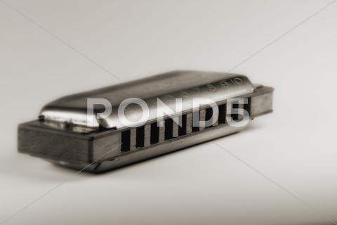 Close up of blues harmonica , shallow dof retro style toned photo aged, audio, band, blow, blues, brass, country, diatonic, draw, folk, harmonica, harp, instrument, instruments, isolated, jazz, metal, mouth, music, note, object, old, plate, pop, reed, retro, rock, studio, toned, used, vertical, vintage, white