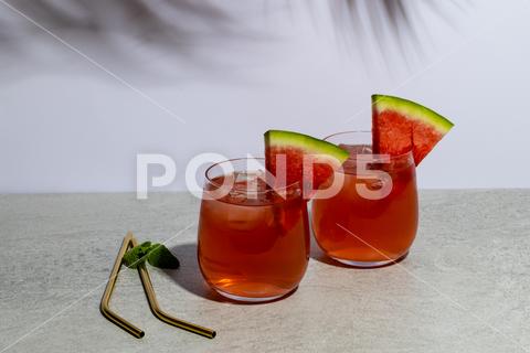 Glasses with drinks and watermelon in grey space. Drinks, cocktails, alcohol, beverages and party concept. No People, Glass, Drink, Watermelon, Grey, Space, Cocktail, Alcohol, Beverage, Party, Concept, Refreshment, Bar, Liquid, Juice, Restaurant, Cafe, Celebration, Table, Design, Background, Abstract, Fresh, Light