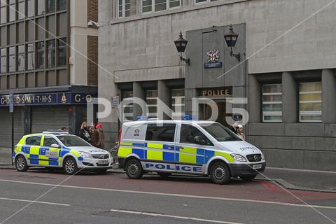 Two Patrol Vehicles in Front Police Station at Bishopsgate in London, UK. police, Police Station, paddy wagon, station, London, England, London, UK, editorial, patrol car, Bishopshgate, patrol, car, vehicle, van, street, front, city, town, traffic, people, safety, goldsmiths, building, entrance, paddy, wagon, day