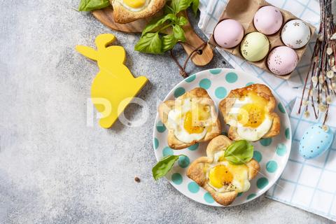 Easter breakfast idea. Scrambled eggs in puff pastry with cheese and bacon on a stone background. View from above. Copy space. scrambled, bacon, breakfast, snack, pastry, lunch, appetizer, eggs, eat, dish, dinner, appetizer meal, bakery, background, cheese, food, puff, breakfast food, appetizing, fried egg, puff pastry, above, bake, beautiful, bunny, buns, cake, celebration, cinnamon, colorful eggs, cooked, cookie, copy, creative, culinary, decor, easter bunny, easter eggs, festive, flat lay, happy easter, holiday, menu, party, rabbit, recipe, springtime, sweet, table