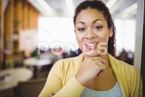 Portrait of smiling businesswoman with hand on chin in office cafeteria 20s, Young Adult, Woman, Female, Black, Indoors, Looking At Camera, Hand On Chin, Businesswoman, Cafeteria, Cafe, Creative Office, Smart, Elegant, Classy, Stylish, Corporate, Office, Job, Career, Profession, Business, Occupation, Cool, Style, Break, Confidence, Professional, Attractive, Pretty, Successful, Confident, Beautiful, Smiling, Happiness, Cheerful, Casual Clothing