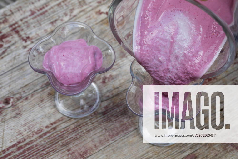 Selbstgemachtes Himbeersofteis aus Naturjoghurt, Quark mit Fruechten, Bananen und wilde Himbeeren wurden vermixt und werden in Eisbecher gefuellt, Serienbild 3 4 selfmade soft ice cream made of yogurt, qvark and fruits, bananas and wild raspberries are mixed, series picture 3 4 BLWS698270