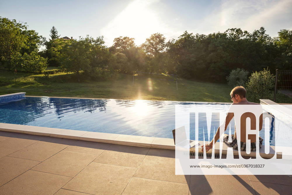 Freelancer sitting with laptop on poolside model released, Symbolfoto property released, MAMF02903