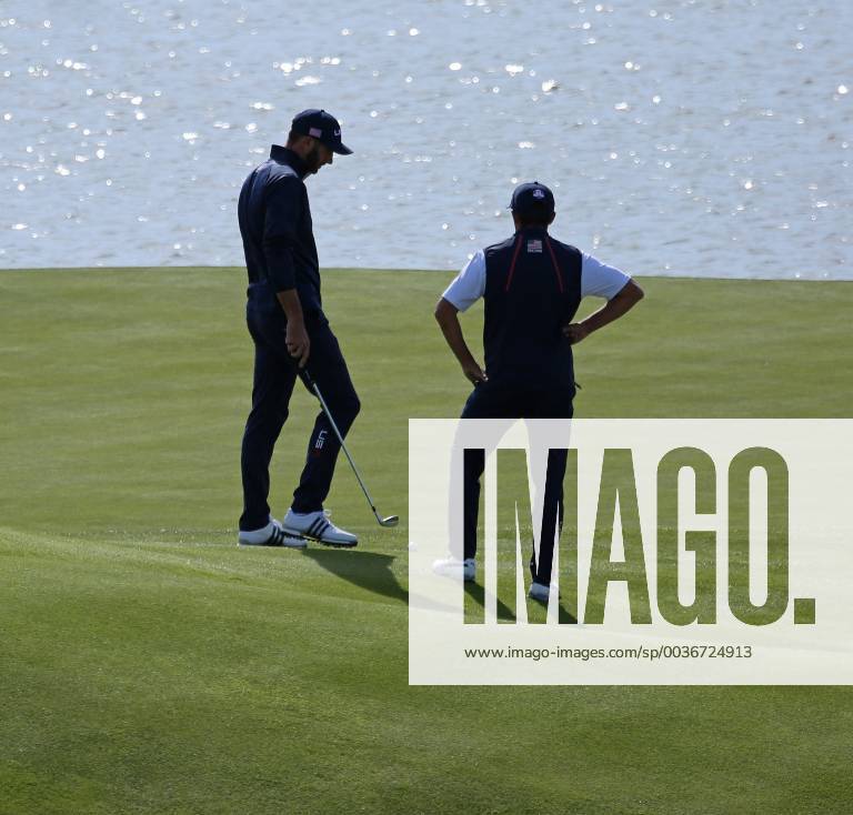 Dustin Johnson (L) and Rickie Fowler chat on the green on day two of the Ryder Cup at Le Golf National in Guyancourt near Paris on September 29, 2018. Johnson and Fowler lost their match to Paul Casey and Tyrrell Hatton 3 & 2. PAR20180929013 DAVIDxSILPA