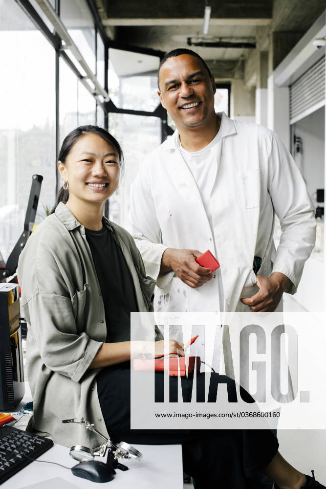 Portrait of happy multiracial male and female technicians at repair shop Germany, Berlin, model released, property released